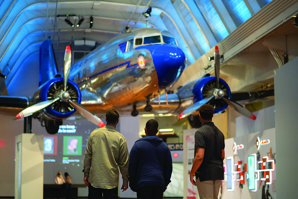 Guests stop underneath the DC-3 located in the center of Henry Ford Museum of American Innovation